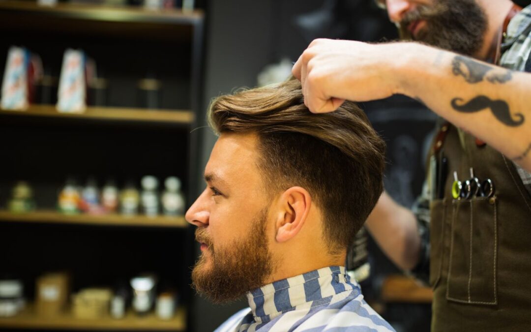 Barber oglądający włosy klienta przed strzyżeniem w nowoczesnym barbershopie w Bochni